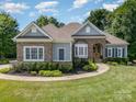 Beautifully landscaped front yard with a well-maintained lawn, stone accents, and a welcoming entrance at 7913 Buena Vista Dr, Denver, NC 28037