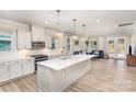 Open-concept kitchen featuring a large island, stainless steel appliances, and stylish pendant lighting, flowing into the living area at 9534 Liberty Hill Dr # 196, Mint Hill, NC 28227