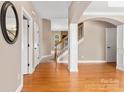 Foyer with hardwood floors leading to staircase with decorative molding and a glimpse of a fireplace at 1016 Filly Dr, Indian Trail, NC 28079