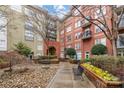 Exterior courtyard with benches, stone features, lush landscaping, and views of multi-story condo buildings at 1320 Fillmore St # 419, Charlotte, NC 28203