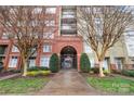 Exterior entrance with brick archway, signage indicating address, and manicured landscaping at 1320 Fillmore St # 419, Charlotte, NC 28203