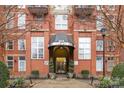 Exterior entrance to building with a covered awning, brick facade, manicured landscaping, and glass doors at 1320 Fillmore St # 419, Charlotte, NC 28203