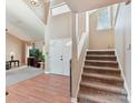 Open foyer featuring hardwood floors, a staircase, and a view into the bright living room at 13424 Portside Ct, Charlotte, NC 28278