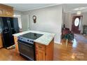 Modern kitchen island with an electric cooktop, seating and hardwood floors at 1465 Earl St, Hickory, NC 28602