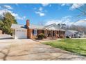 Well-maintained brick home featuring an attached garage, spacious driveway, and lush green lawn, showcasing suburban living at 1558 Pine Creek Rd, Gastonia, NC 28056