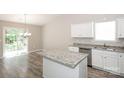 Modern kitchen featuring granite countertops, stainless steel appliances, island, and sliding glass doors at 221 Chicago Ln, York, SC 29745