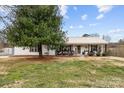 Charming single-story home featuring a metal roof and rocking chair front porch at 24253 Old Aquadale Rd, Albemarle, NC 28001