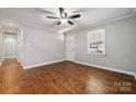 Well-lit bedroom featuring hardwood floors, a ceiling fan, and a white door leading to the exterior at 259 Unionville Indian Trail W Rd, Indian Trail, NC 28079