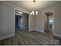 Open-concept dining room with modern light fixture, neutral walls, and wood-look flooring at 287 Luray Way # 450, Rock Hill, SC 29730
