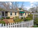 Inviting yellow home featuring a white picket fence and established landscaping at 311 3Rd Avenue Se Dr, Hickory, NC 28602