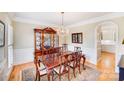Formal dining room with a large wooden table, ornate china cabinet, elegant chandelier, and hardwood floors at 3716 Drayton Hall Ln, Charlotte, NC 28270