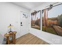 Bright entryway features wood-look flooring, white walls, and eye-catching palm tree artwork at 404 Plaza Dr, Harrisburg, NC 28075