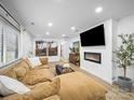 Spacious living room featuring a modern fireplace, large sectional sofa, and stylish decor at 404 Plaza Dr, Harrisburg, NC 28075