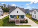 Charming home with blue siding, yellow door, brick accents, and a well-manicured front yard at 508 Standpipe Hl, Cramerton, NC 28032