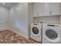 Neat laundry room with washer, dryer, overhead cabinets, and attractive tile flooring at 508 Standpipe Hl, Cramerton, NC 28032