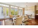 Sun-filled living room with expansive windows, hardwood floors, comfortable seating, and an open dining area at 5425 Closeburn Rd # 309, Charlotte, NC 28210