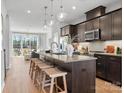 Modern kitchen with dark cabinetry, an island with seating, and open access to the living area and balcony at 5640 Kingspan Dr, Charlotte, NC 28217