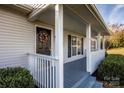 Inviting front porch with decorative wreath, white pillars, and neat landscaping at 9450 Paul Payne Store Rd, Stony Point, NC 28678