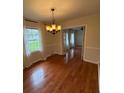 The dining room has hardwood floors, a chandelier and large windows at 100 Chadmore Dr, Charlotte, NC 28270