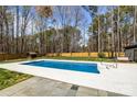 A backyard pool surrounded by a spacious concrete deck and grassy area at 10405 Club Car Ct, Mint Hill, NC 28227