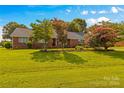 Beautiful lawn, trees, and flowering shrubs surrounding a classic brick home at 105 Baymount Dr, Statesville, NC 28625
