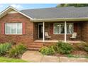 Inviting front porch with brick steps and quaint seating, perfect for relaxing outdoors at 105 Baymount Dr, Statesville, NC 28625