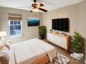 Bright bedroom features large window, stylish furniture, and a ceiling fan for added comfort at 10940 Wild Dove Ln, Charlotte, NC 28277