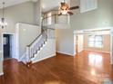 Spacious living room with hardwood floors, high ceilings, and a staircase leading to the second floor at 10940 Wild Dove Ln, Charlotte, NC 28277