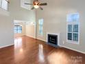 Spacious living room with hardwood floors, a fireplace, and lots of natural light at 10940 Wild Dove Ln, Charlotte, NC 28277
