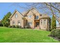Handsome brick and stone home with lush green lawn, showcasing classic design and curb appeal at 1125 Bugle Ln, Newton, NC 28658
