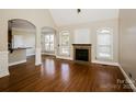 Bright living room boasts hardwood floors, fireplace, neutral walls, and arched doorway for open feel at 1125 Bugle Ln, Newton, NC 28658