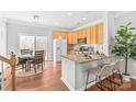 Bright kitchen featuring granite countertops, stainless steel appliances, breakfast bar, and hardwood floors at 130 Clydesdale Ct, Matthews, NC 28104