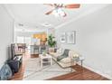 Bright living room with hardwood floors, crown molding, and an open floor plan leading to the kitchen and dining area at 130 Clydesdale Ct, Matthews, NC 28104