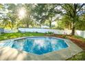Backyard with a refreshing in-ground pool surrounded by a concrete patio and a tall white fence at 142 Wilson Ne St, Concord, NC 28025
