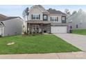 Beautiful two-story home with stone accents, a well-manicured lawn, and a two-car garage at 146 Dogwood Grove Pl, Troutman, NC 28166