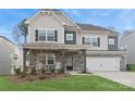 Charming two-story home with stone accents, a well-manicured lawn, and a two-car garage at 146 Dogwood Grove Pl, Troutman, NC 28166