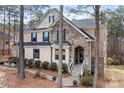 Beautiful home featuring a stone and brick facade with a covered front entrance and manicured shrubs at 147 Belfry Loop, Mooresville, NC 28117