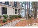 Charming brick home with a stone entrance, complimented by a neatly landscaped walkway and lush greenery at 147 Belfry Loop, Mooresville, NC 28117