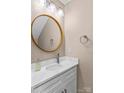 Contemporary half bath features a round mirror, modern lighting, and stylish fixtures at 163 Singleton Rd, Mooresville, NC 28117