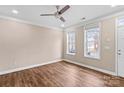 A bright living room features a ceiling fan and two windows with neighborhood views at 163 Singleton Rd, Mooresville, NC 28117