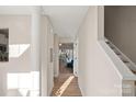 Bright hallway leading to a naturally lit living area with beautiful hardwood flooring at 17527 Tuscany Ln, Cornelius, NC 28031