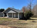 Quaint home with gray siding, a brick chimney, and a small covered front porch perfect for enjoying the outdoors at 188 13Th Se St, Hickory, NC 28602