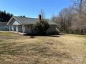 Cozy single-Gathering home with gray siding, a brick chimney, and a spacious yard with mature trees at 188 13Th Se St, Hickory, NC 28602