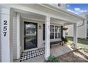 Inviting front porch with black door, a cozy bench, and a stylish buffalo check doormat for a welcoming touch at 257 Notable Ln, Rock Hill, SC 29732