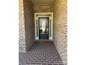 Close-up of front door with brick surround and decorative glass, creating a welcoming entrance at 2608 Glyncastle Way, Gastonia, NC 28056