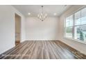 Open dining room with wood floors, a chandelier, and natural light from a large window at 2783 Ashton Park Ln # 67, Monroe, NC 28110