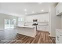 A modern kitchen boasts white cabinets, stainless appliances, an island, and an open layout at 2783 Ashton Park Ln # 67, Monroe, NC 28110