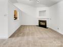 Spacious living room featuring a cozy fireplace and neutral carpet, offering a blank canvas for personalization at 2924 Zion Renaissance Ln, Charlotte, NC 28269