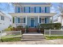 Charming two-story home featuring a welcoming front porch with white columns and a well-manicured lawn and picket fence at 3208 Fifth Baxter Xing, Fort Mill, SC 29708
