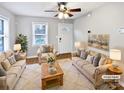 Bright living room featuring hardwood floors, a ceiling fan, and neutral-toned furniture with patterned pillows at 325 Oregon St, Charlotte, NC 28208